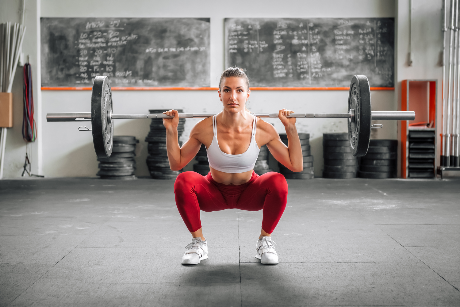 A women squatting with an olympic bar